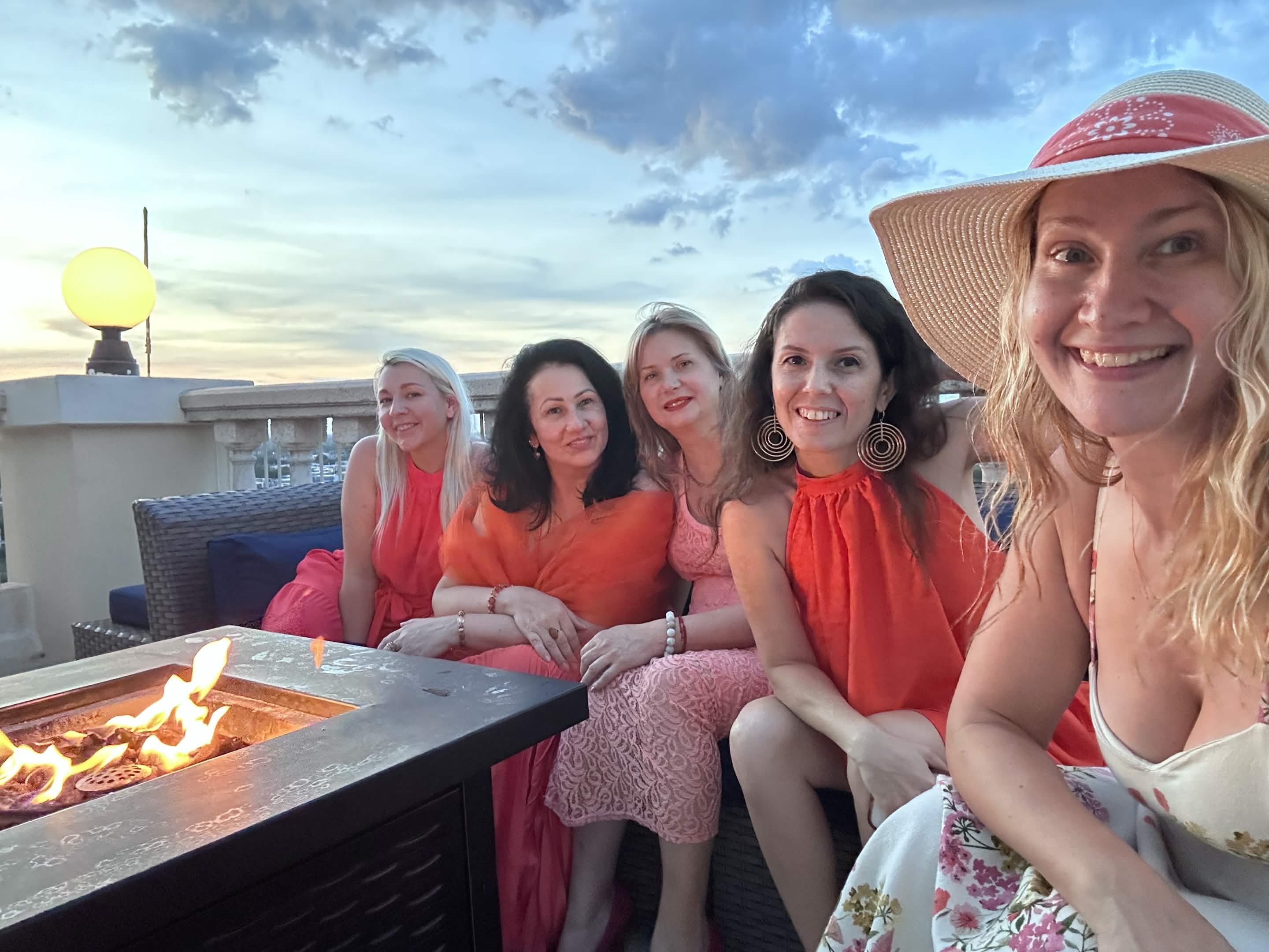 Love with a group of women gathered on a rooftop at sunset